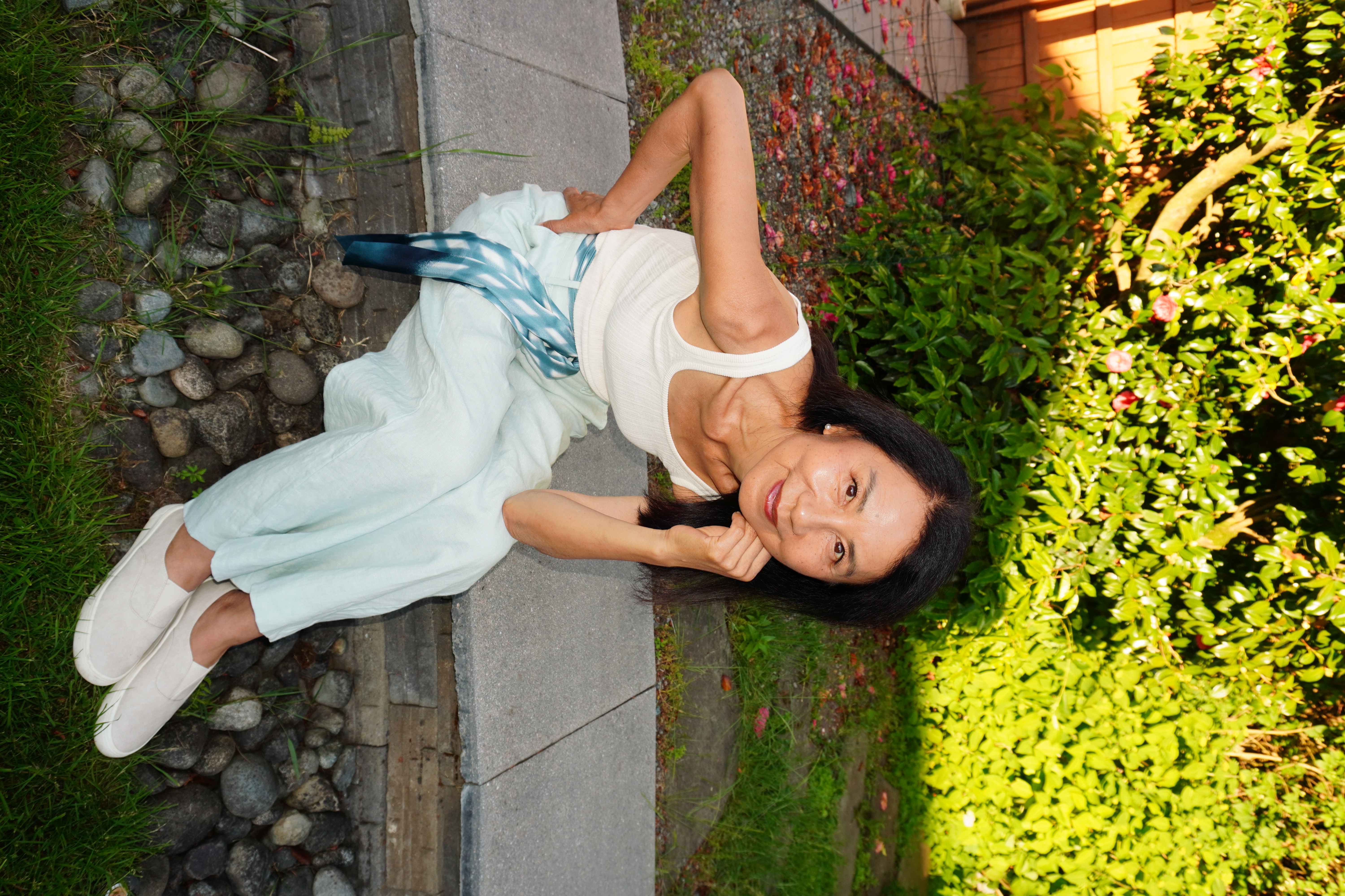Janney sitting on the garden wall under a camellia