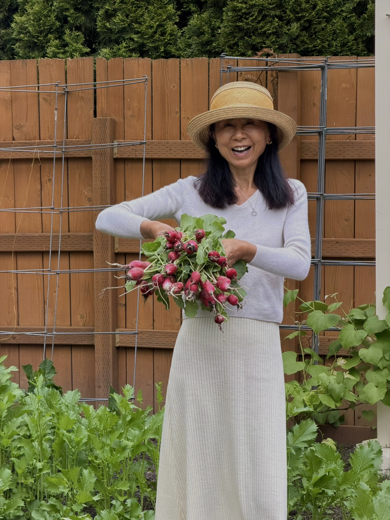 Janney holding a bunch of radishes pulled from a young bed